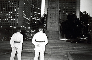 British soldiers taking down flags from the war memorial in Central at sunset, 9 November 1996.