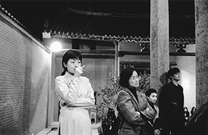 Guests listening to a performance at a New year's Eve party in the Tang clan ancestral hall, Ping Shan, with a view of the courtyard, 31 December 1996