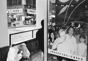 Photo of Governor Christopher Patten in the window of a herbal tea shop in Sheung Wan, showing him sampling a herbal drink, 3 February 1997