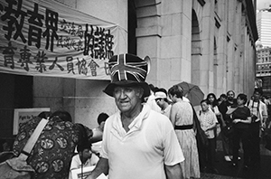 Demonstrators and man with Union Jack hat outside the then Legislative Council Building on the last day of British sovereignty, 30 June 1997