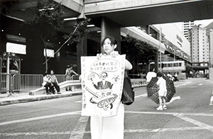 Protester with placard near the Convention and Exhibition Centre on the occasion of a visit to that location by then-President Jiang Zemin, 1 July 1998