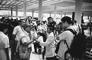 Passenger complaining to the media about delays, in the Arrivals Hall of the new Hong Kong International Airport, Chek Lap Kok, 7 July 1998