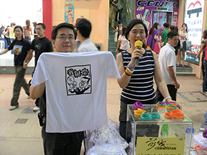 Pro-democracy legislator Emily Lau selling silicone wristbands in support of the Frontier Party and T-shirts depicting Hong Kong tycoon Li Ka-shing and Chief Executive Donald Tsang as mutually supportive, Great George Street, Causeway Bay, 4 June 2005