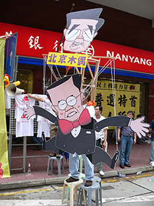 Donald Tsang being portrayed as a puppet of Beijing (in the form of Chinese leader Hu Jintao). Alongside the democracy march, between Causeway Bay and Wanchai, 1 July 2005