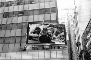 Digital screen on Queen's Road Central showing scenes from the American invasion of Iraq, 25 March 2003