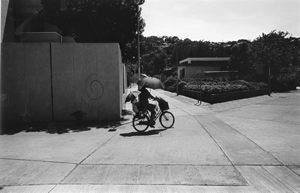 Cyclist with umbrella to protect against strong sun, Cheung Chau, 25 September 2003