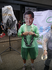 Demonstrator with Leung Chun-ying mask, on the annual pro-democracy march, 1 July 2013