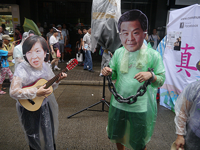 Demonstrators with Leung Chun-ying and Fanny Law masks on the annual pro-democracy march, 1 July 2013