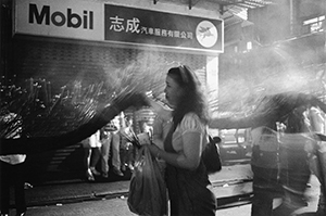 Woman placing incense sticks on the Tai Hang Fire Dragon to represent its fiery scales, 28 September 1996