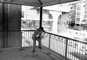 Elevated roadway under construction, with man resting on a pedestrian walkway employing a makeshift 'hammock', Sheung Wan, 24 April 1996