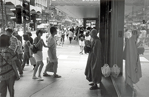 A person dressed as a monk on Queen's Road Central, 13 July 1996