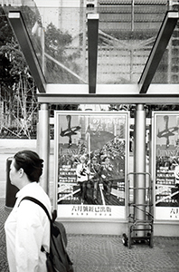 Magazine advertisment on a bus stop, showing a fabricated image of the People's Liberation Army marching in Hong Kong, Central, 7 June 1997