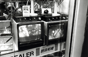 Two CCTV monitors in a shop window, Causeway Bay, 13 September 1997