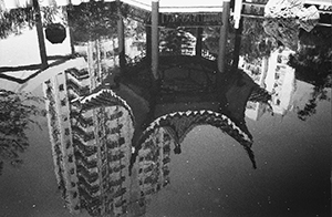 Reflection of a pavilion in the pond, with high rise buildings behind, Hollywood Road Park, close to the spot where the British first landed in Hong Kong, 10 February 1998