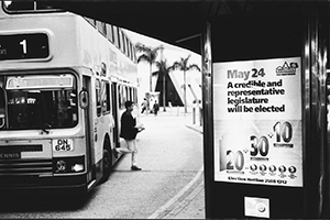 Government poster on a bus shelter asserting that forthcoming Legislative Council elections will be democratic, despite the fact that only a minority of the seats are in geographical constituencies where voting is open to all, 5 March 1998