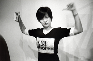 Elaine Ng, wearing a T-shirt designed by Leung Po Shan, with the slogan 'Love the Fucking Country,' at an exhibition opening at Hanart TZ Gallery, Central, 29 June 1998