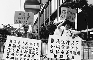 Protesters with banners near the Convention and Exhibition Centre on the occasion of a visit to that location by then-President Jiang Zemin, 1 July 1998
