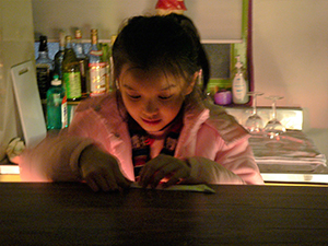 Young visitor concentrating on the act of making an origami crane, Sense 99, Wellington Street, 15 January 2005