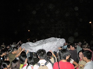 People preparing a paper hot air balloon, as part of a traditional Mid-Autumn Festival celebration at Sheung Wo Hang Village, north-eastern New Territories, 18 September 2005