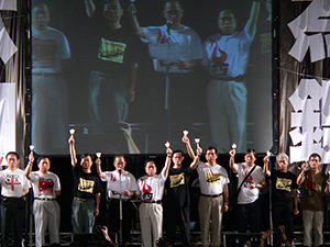 People on the stage holding up candles during the June Fourth memorial rally, Victoria Park, 4 June 2005