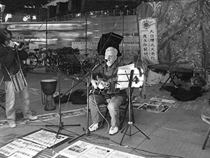 Franco Mella performing at the ‘Occupy’ protest camp in the public plaza beneath the Hong Kong and Shanghai Bank headquarters, Central, 12 December 2011