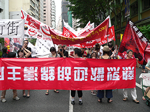 Participants holding banners devised by artists in the annual pro-democracy march, 1 July 2007