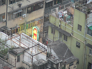 View across rooftops with a neon sign switched on as dusk approaches, Sheung Wan, 18 October 2004