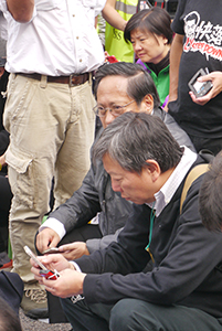 Politician Lee Cheuk-yan (front) and Albert Ho (back) participating in a sit-in on the final day of the Admiralty Umbrella Movement occupation site, 11 December 2014