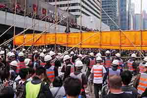 Workers removing a barricade, on the final day of the Admiralty Umbrella Movement occupation site, Harcourt Road, 11 December 2014