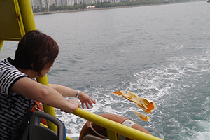 Casting paper offerings on the water whilst on a boat to Joss House Bay on the birthday of Tin Hau, 22 April 2014