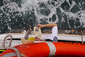 Casting paper offerings on the water whilst on a boat to Joss House Bay on the birthday of Tin Hau, 22 April 2014