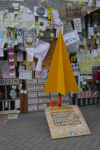 A paper umbrella in front of posters at the Admiralty Umbrella Movement occupation site, Harcourt Road, 15 November 2014