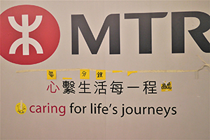 Stickers on an MTR hoarding, Admiralty, 19 November 2014