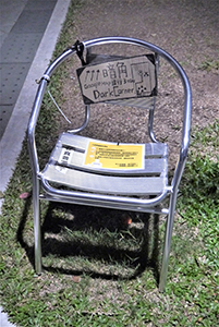 Chair with a sign giving directions to the location Ken Tsang was beaten up by a group of policemen, Admiralty Umbrella Movement occupation site, 10 December 2014