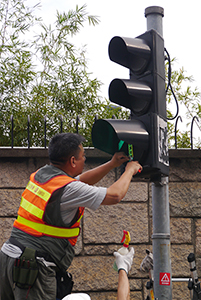 Removing a sticker from a traffic light, on the final day of the Admiralty Umbrella Movement occupation site, Harcourt Road, 11 December 2014