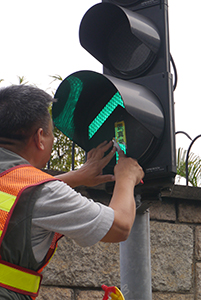 Removing a sticker from a traffic light, on the final day of the Admiralty Umbrella Movement occupation site, Harcourt Road, 11 December 2014