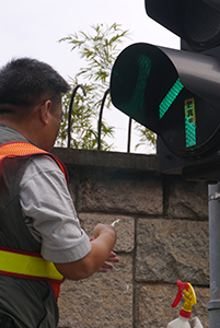 Removing a sticker from a traffic light, on the final day of the Admiralty Umbrella Movement occupation site, Harcourt Road, 11 December 2014