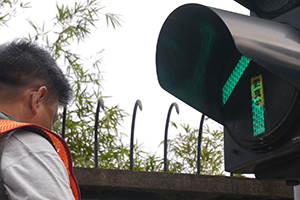 Removing a sticker from a traffic light, on the final day of the Admiralty Umbrella Movement occupation site, Harcourt Road, 11 December 2014