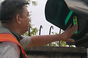 Removing a sticker from a traffic light, on the final day of the Admiralty Umbrella Movement occupation site, Harcourt Road, 11 December 2014