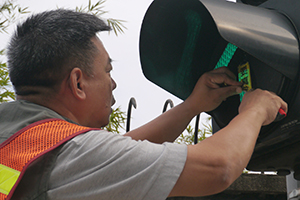 Removing a sticker from a traffic light, on the final day of the Admiralty Umbrella Movement occupation site, Harcourt Road, 11 December 2014