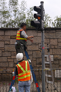 Removing a sticker from a traffic light, on the final day of the Admiralty Umbrella Movement occupation site, Harcourt Road, 11 December 2014