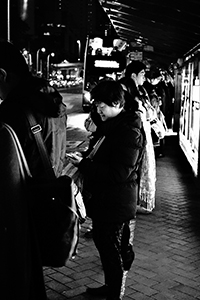 People at a bus stop outside Pacific Place, Admiralty, 24 December 2014