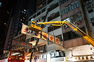 Workers removing a shop sign, Queen's Road West, Sheung Wan, 31 December 2014