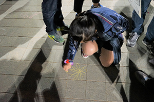 A woman draws on the floor, Tamar Park, Admiralty, 1 January 2015