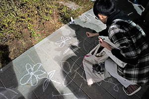 Drawing graffiti on the ground, Tamar Park, Admiralty, 1 January 2015