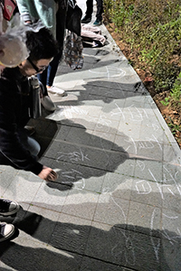 Drawing graffiti on the ground, Tamar Park, Admiralty, 1 January 2015