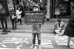 Participant holding a chalk board, during a pro-democracy march from Victoria Park to Central, Hennessy Road, 1 February 2015