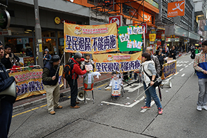Street booth of the Alliance for Universal Pension, with images of Leung Chun-ying, at a pro-democracy march from Victoria Park to Central, Hennessy Road, 1 February 2015