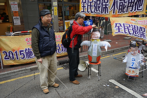 Street booth of the Alliance for Universal Pension, with images of Leung Chun-ying, at a pro-democracy march from Victoria Park to Central, Hennessy Road, 1 February 2015