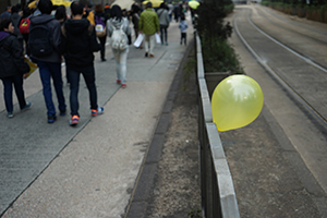 A yellow balloon tied to a railing, during a pro-democracy march from Victoria Park to Central, Queensway, 1 February 2015